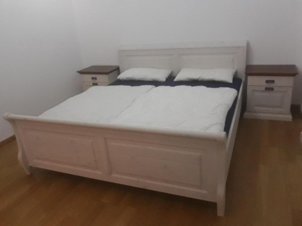 a white bed in a room with two night stands at Joel in Stadtsteinach