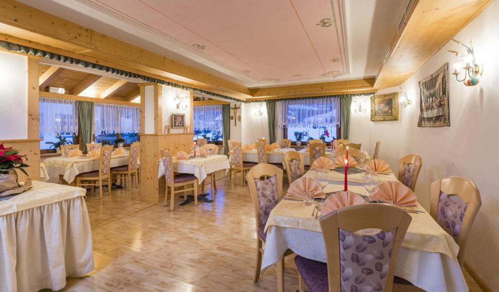 a dining room with tables and chairs and windows at Runcac in Badia