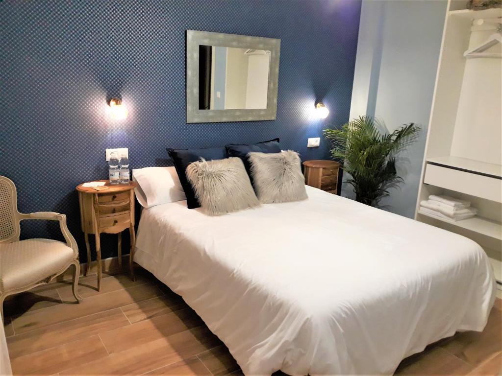 una camera con un grande letto bianco e una sedia di Los Patios de Santander a Santander