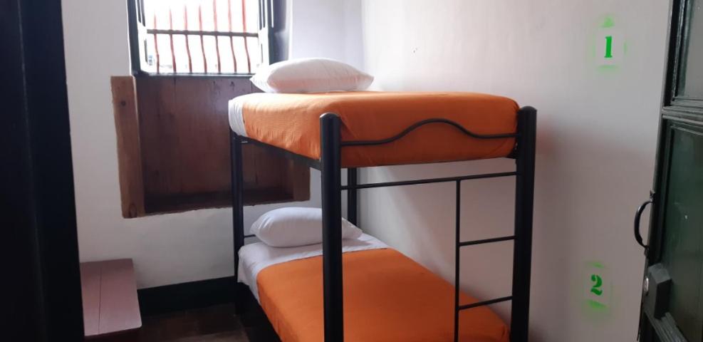 Ce lit superposé se trouve dans un dortoir doté d'un siège orange. dans l'établissement Cedron Hostel, à Bogotá