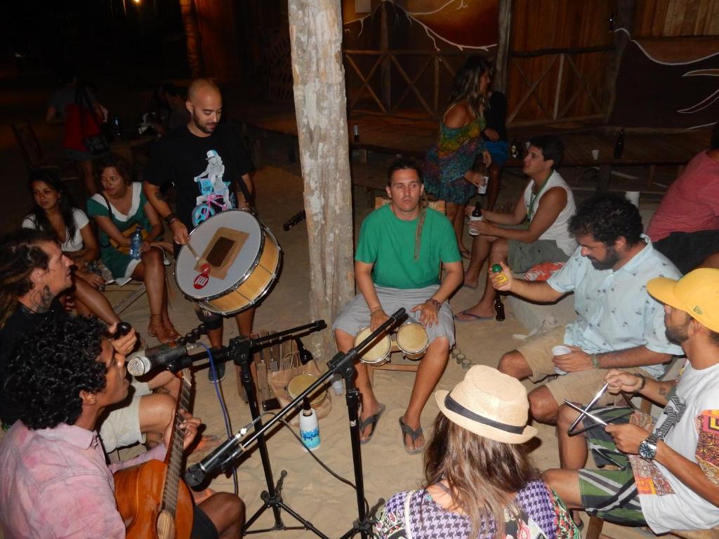 Un groupe de personnes assises dans une foule dans l'établissement Raízes Eco Hostel, à Barra Grande