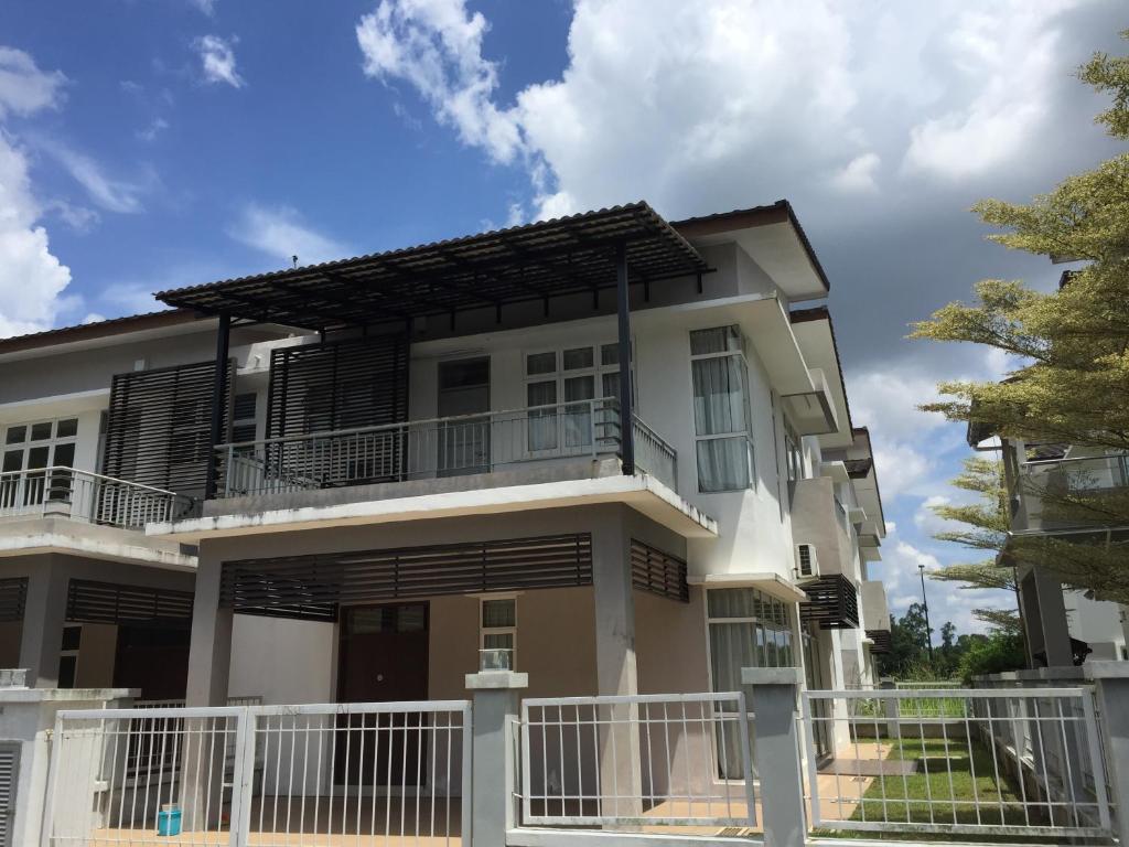 a house with a white fence in front of it at Melaka Homestay Tiara Golf Resort in Malacca