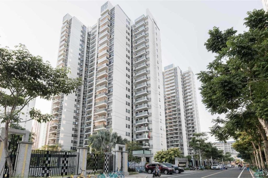 a tall white apartment building in a city at Haikou Meilan District · Xixili Locals Apartment 00175140 in Haikou