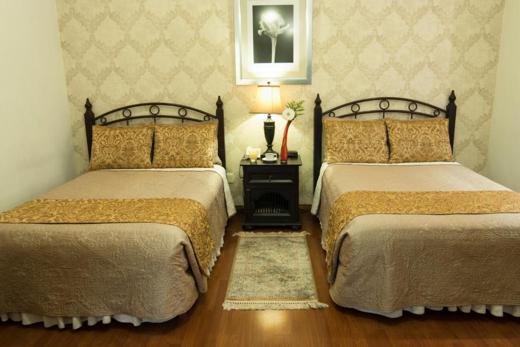 a hotel room with two beds and two lamps at Hotel Casa Divina Oaxaca in Oaxaca City