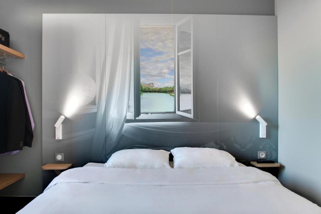 two beds in a bedroom with a window at B&B HOTEL Châlons-en-Champagne in Chalons en Champagne