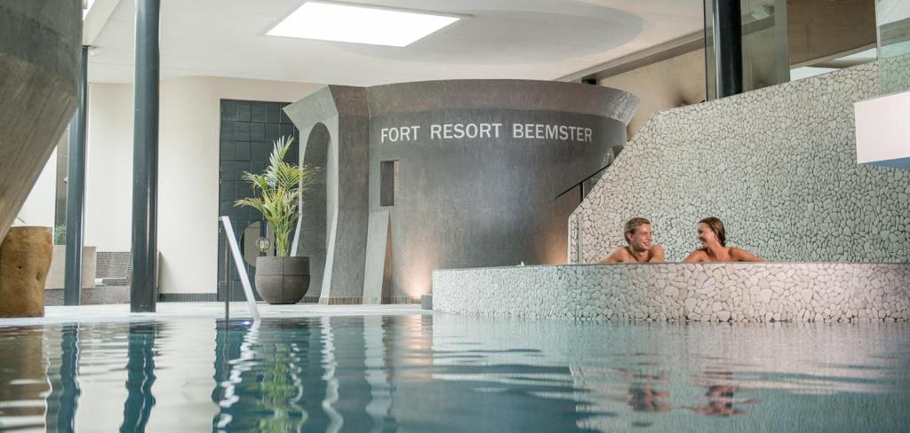 two people in a swimming pool in a building at Fort Resort Beemster in Zuidoostbeemster