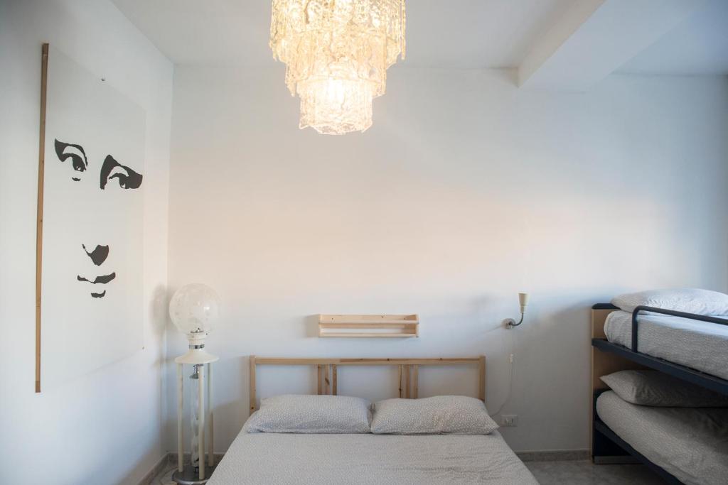 Schlafzimmer mit einem Bett und einem Kronleuchter in der Unterkunft Affittacamere " Il Porto " in Livorno