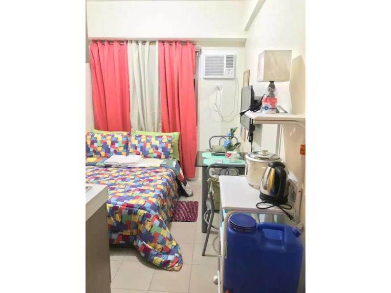 Mały pokój z łóżkiem i stołem z biurkiem w obiekcie Shanilyn Residency Urban Deca Towers EDSA Mandaluyong,UNLIMITED INTERNET AND NETFLIX w mieście Manila