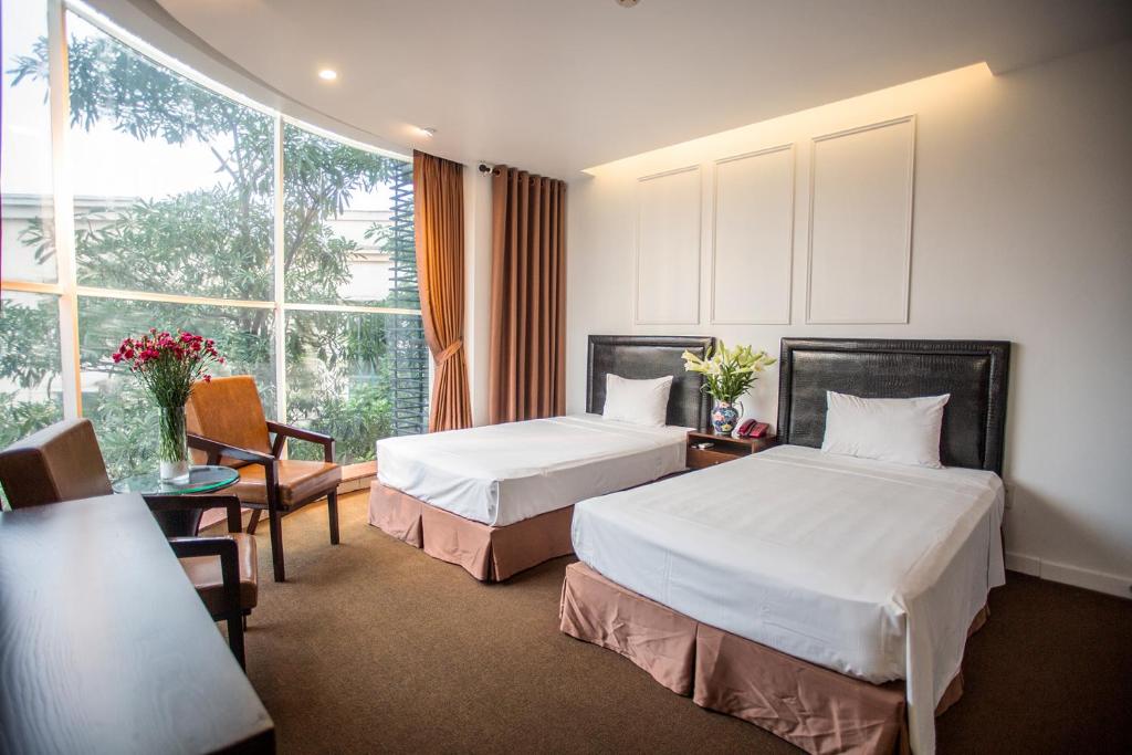 Postel nebo postele na pokoji v ubytování Dinh Hotel