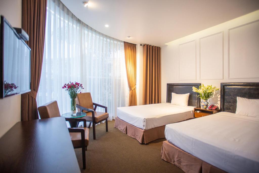 Postel nebo postele na pokoji v ubytování Dinh Hotel