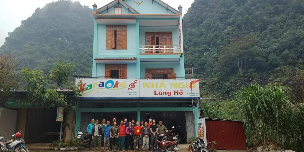 un grupo de personas de pie en frente de un edificio en Lung Ho motel, en Làng Cac
