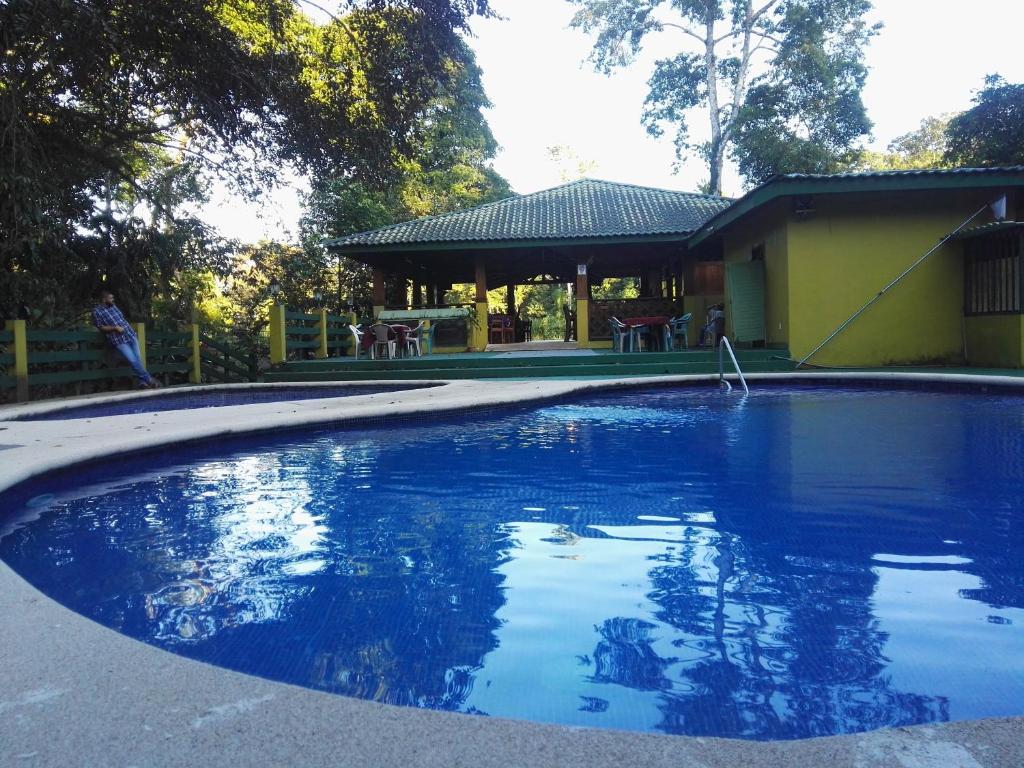 una gran piscina frente a una casa en Hotel Rancho Las Cabañas, en Guápiles