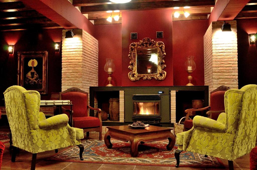 a living room with a fireplace and a table and chairs at Posada de Eufrasio in Lerma