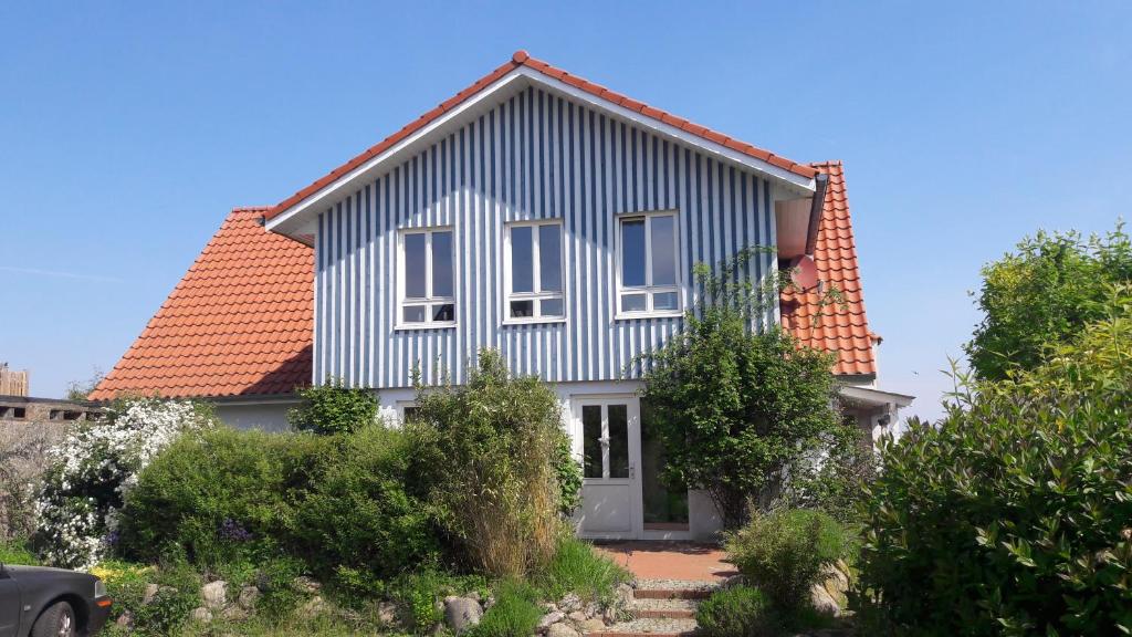 Casa blanca con techo rojo en Ostsee Cottage en Sehlendorf