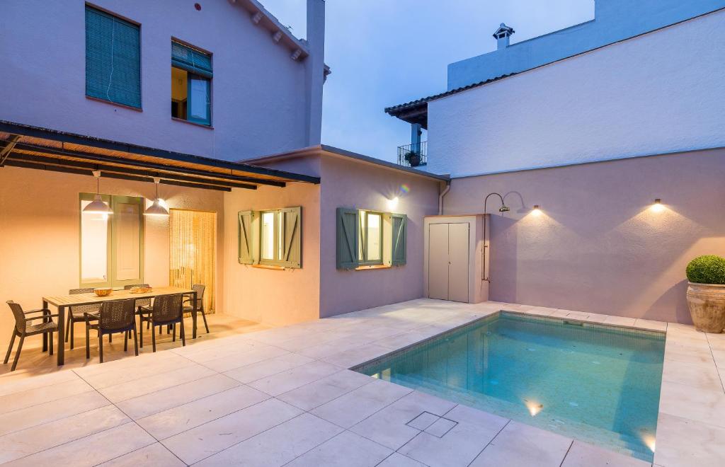 a house with a swimming pool and a table and chairs at CASA DEL PI in Tamariu