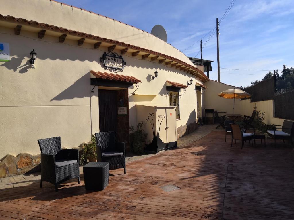 a patio of a house with chairs and an umbrella at Cueva Peralta in Cortes de Baza