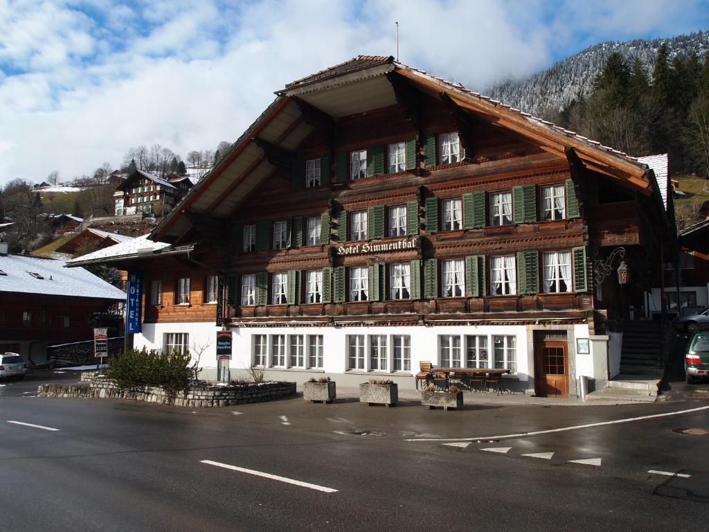 a large wooden building on the side of a street at Hotel Simmental in Boltigen