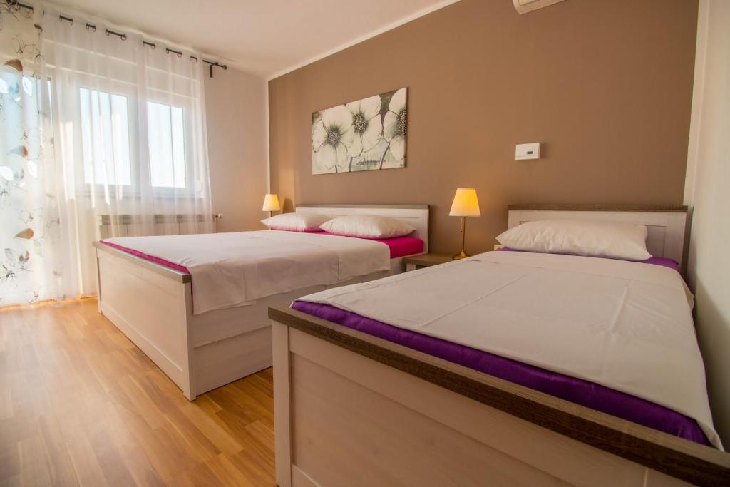a bedroom with two beds and a window at Ivanka 2 in Selce