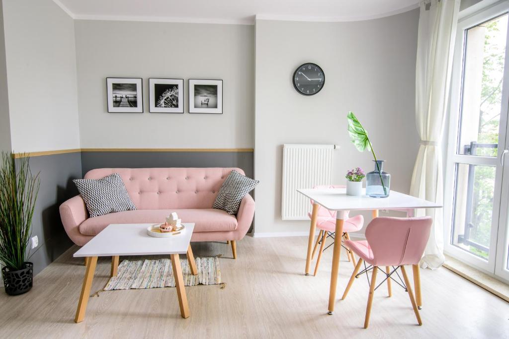 een woonkamer met een roze bank en een tafel bij CANDY ROOM in Olsztyn