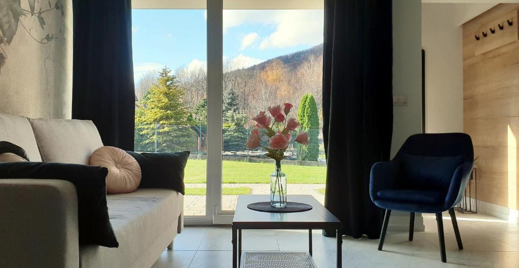 Una sala de estar con un sofá y una ventana grande. en Apartamenty Nad Żylicą przy deptaku - Dream Apart, en Szczyrk