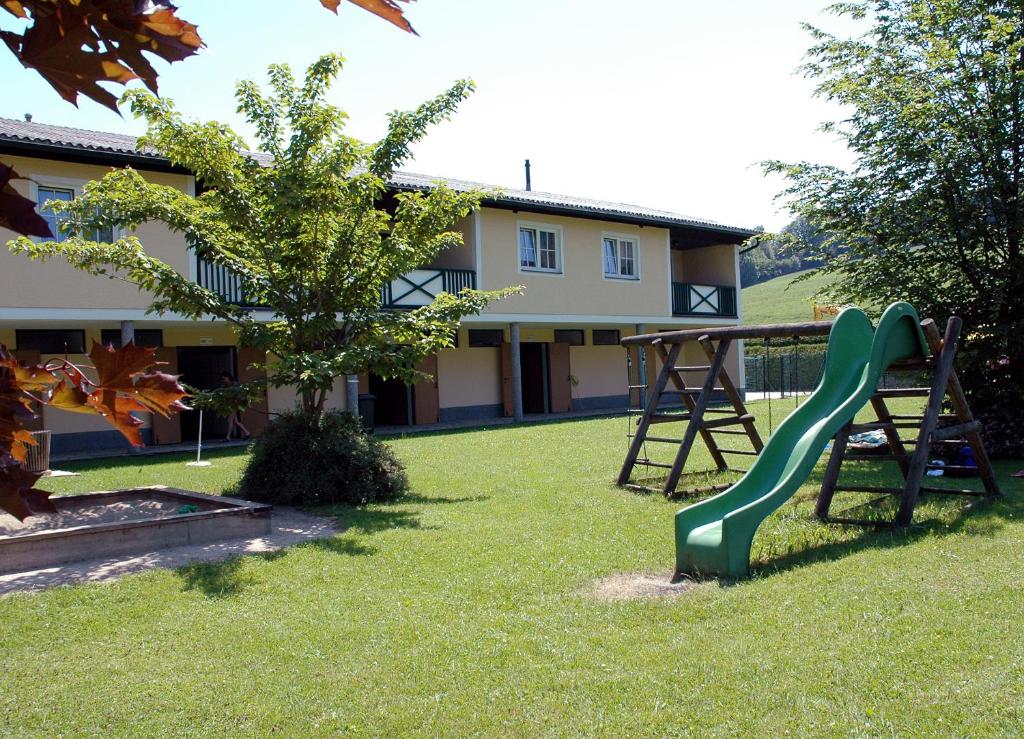 a green slide in the yard of a house at Ferienwohnungen am See in Obertrum am See