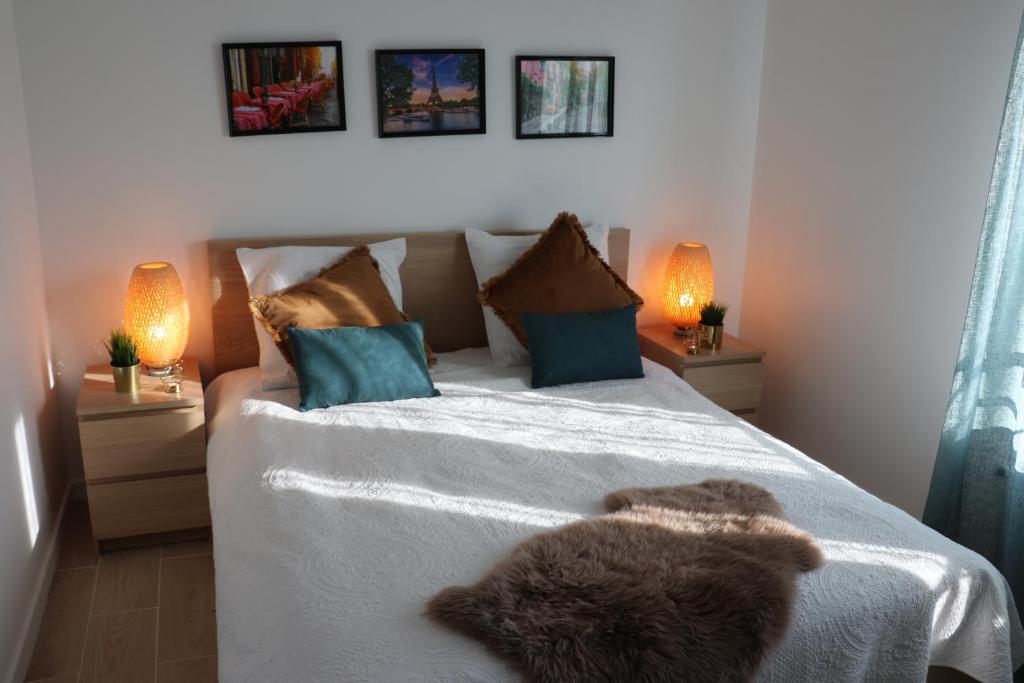um quarto com uma cama grande e 2 candeeiros em Léa de Paris em Noisy-le-Grand