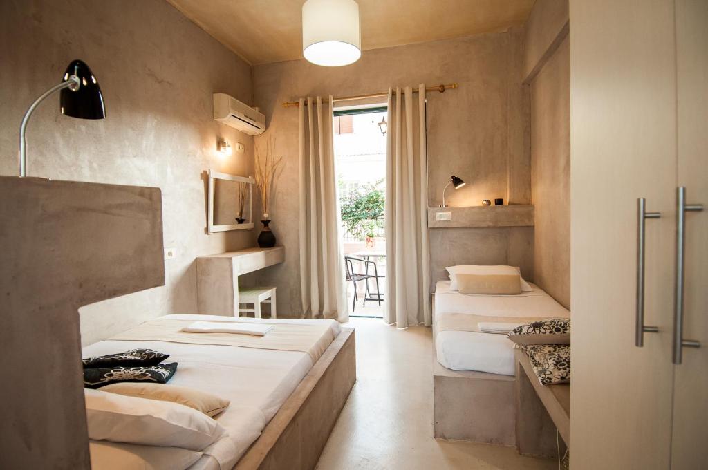 2 camas en una habitación pequeña con ventana en Zante Nest Studios & Apartments, en Alikanas