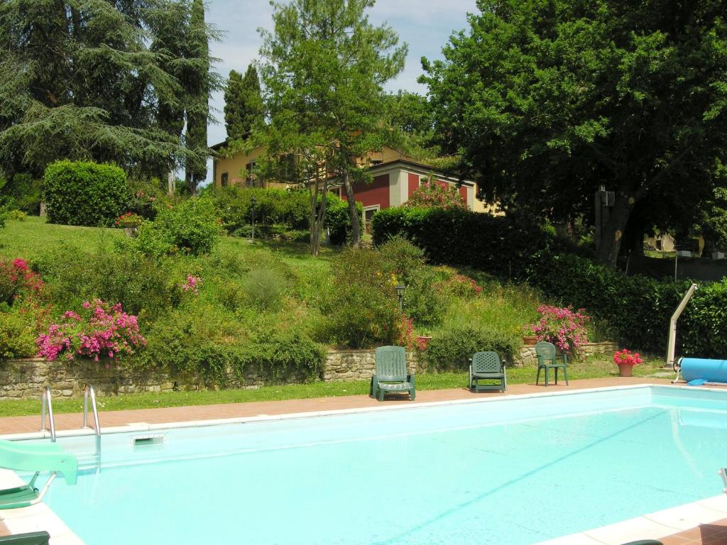 a swimming pool with two chairs and a house at Il Villino in Rabatta