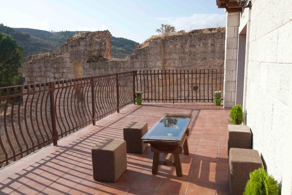 eine Terrasse mit einem Tisch und Stühlen auf dem Balkon in der Unterkunft Alameda I con CHIMENEA Salón y BARBACOA patio in Curiel de Duero