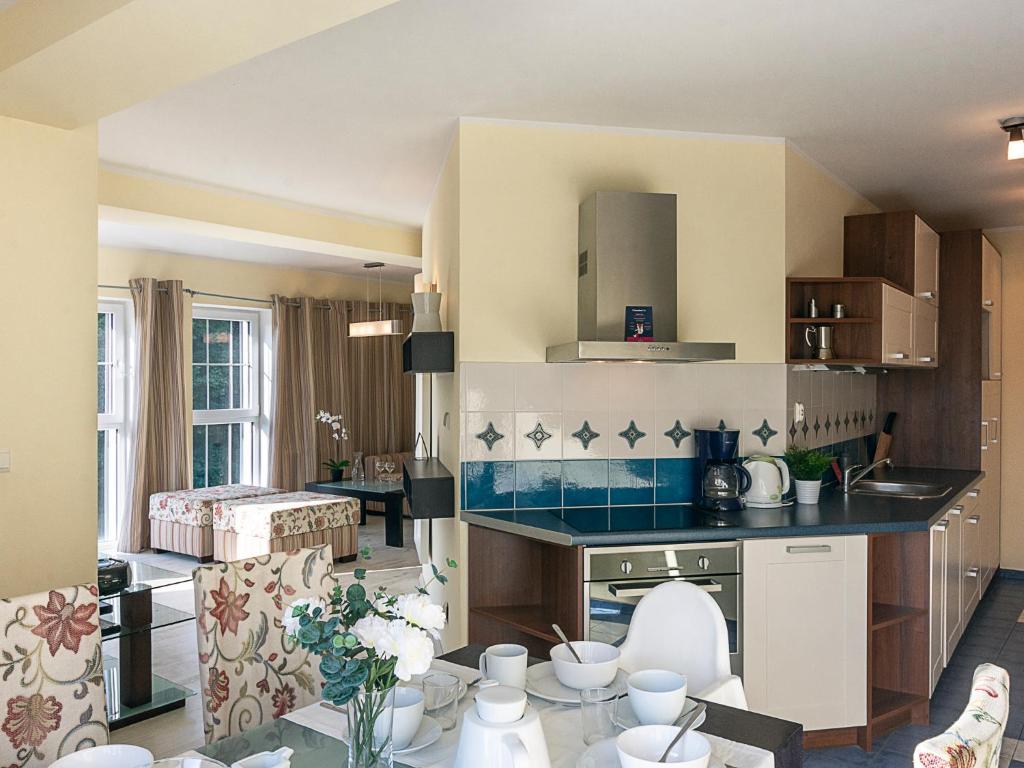 een keuken en een woonkamer met een tafel en stoelen bij VacationClub - Rezydencja Bursztyn Apartament 31 in Świnoujście