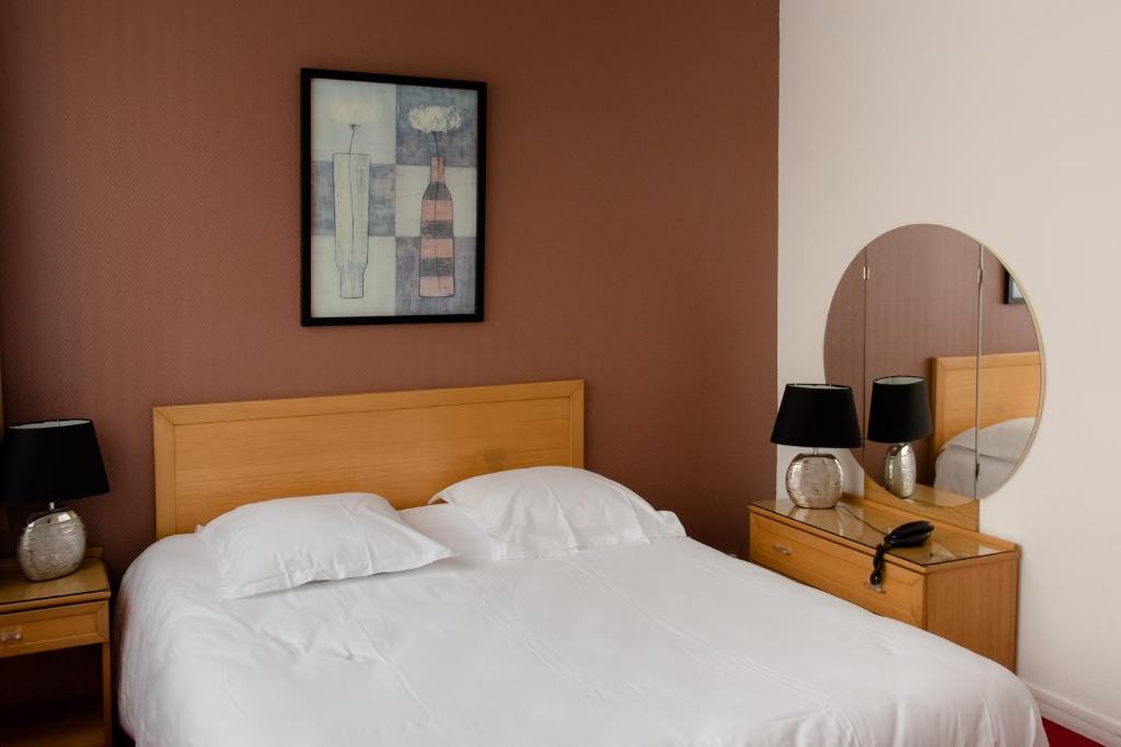 圖爾的住宿－Cit'Hotel Criden，卧室配有白色的床和镜子