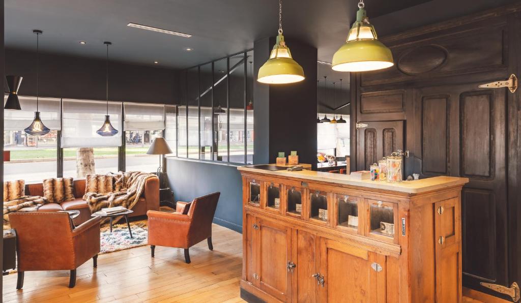 a restaurant with a bar with chairs and a table at Hôtel Clarisse in Paris