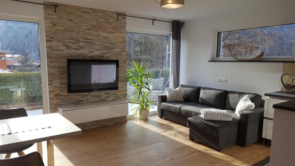 uma sala de estar com um sofá e uma televisão em Alpenappartement Sonne em Umhausen