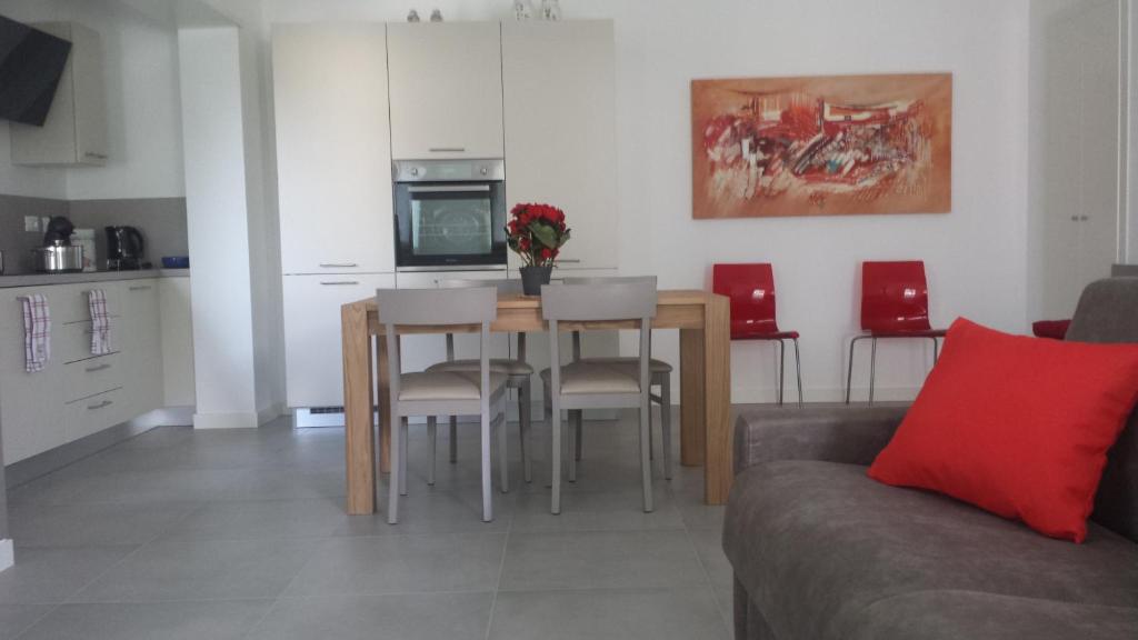 a living room with a table and chairs and a kitchen at Alma Apartment in Sirmione