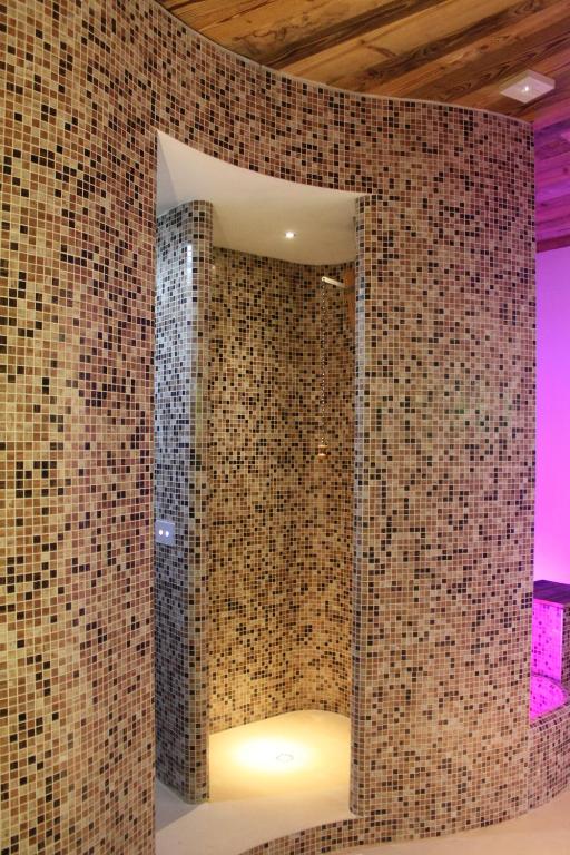 bagno con parete piastrellata e specchio di Albergo Dei Pescatori a Piode
