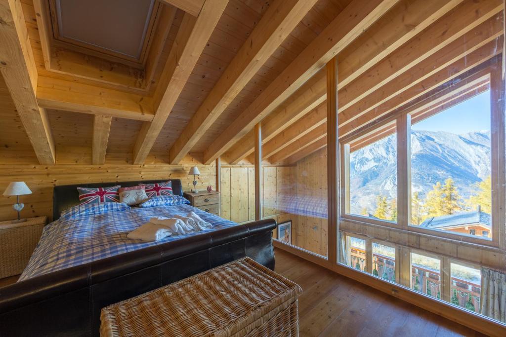 Un dormitorio con una cama y una ventana grande en Chalet Asphodel, en Plan Fey