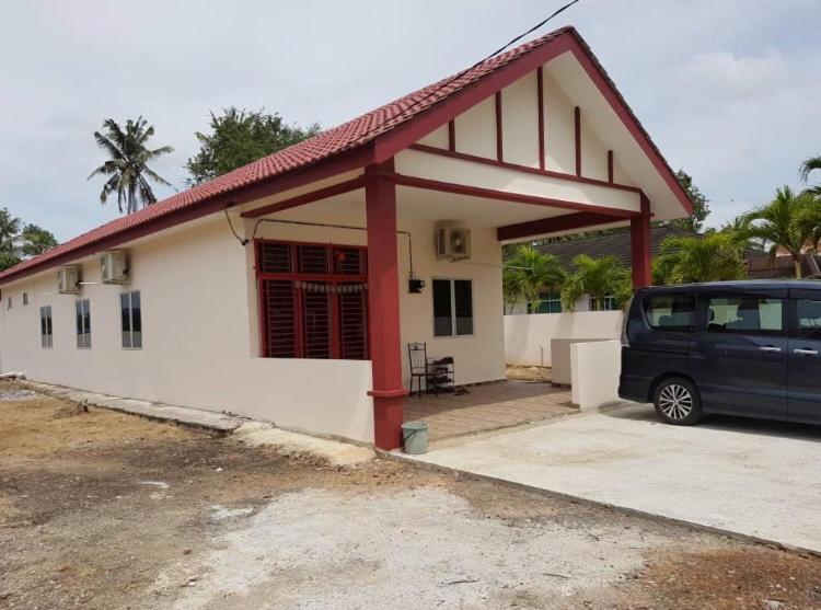 uma carrinha estacionada em frente a uma pequena casa em D’Noon Villa em Arau