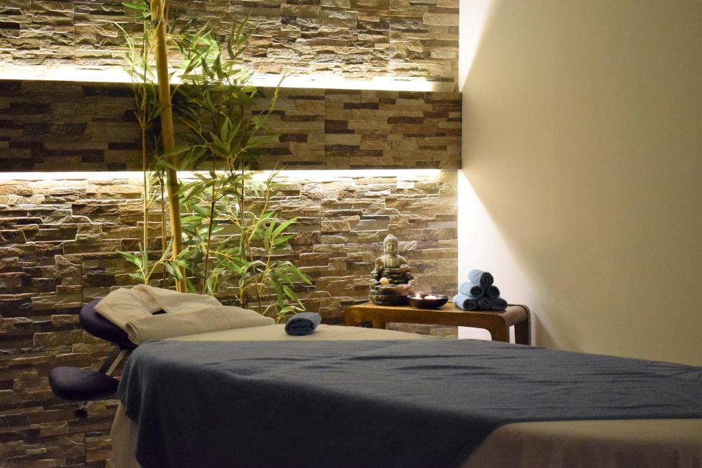 a bedroom with a bed and a stone wall at Vila Alba Resort in Carvoeiro