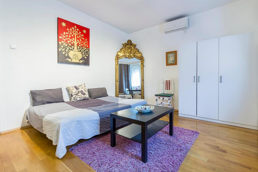 1 dormitorio con cama, mesa y espejo en Mohinga Apartment, en Budapest