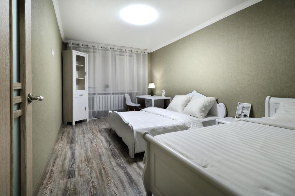 Habitación de hotel con 2 camas y mesa en PaulMarie Apartments on Yakubovskogo str., en Mogilev