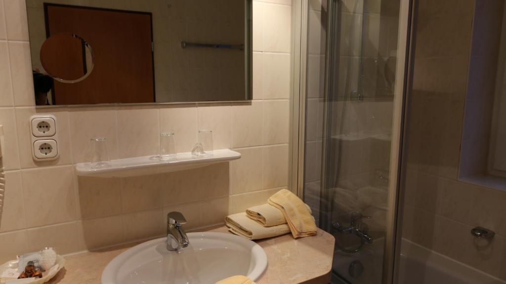 a bathroom with a sink and a shower at Panoramahotel &amp; Restaurant am Marienturm in Rudolstadt