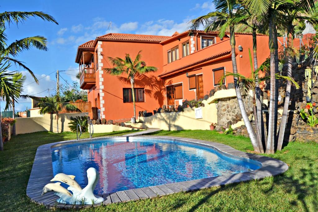 a swimming pool with two swans in front of a house at Casa Victor in La Orotava
