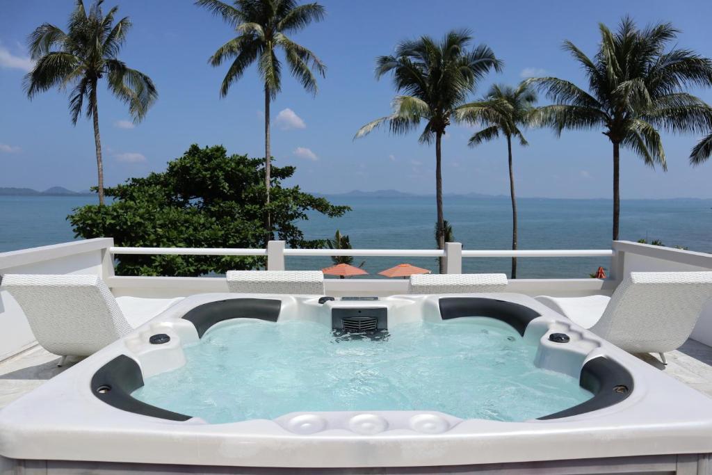 a hot tub on a patio with palm trees at Koh Chang Villa in Ko Chang