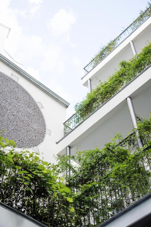 a building with plants on the balconies at Hotel Les Bains Paris in Paris