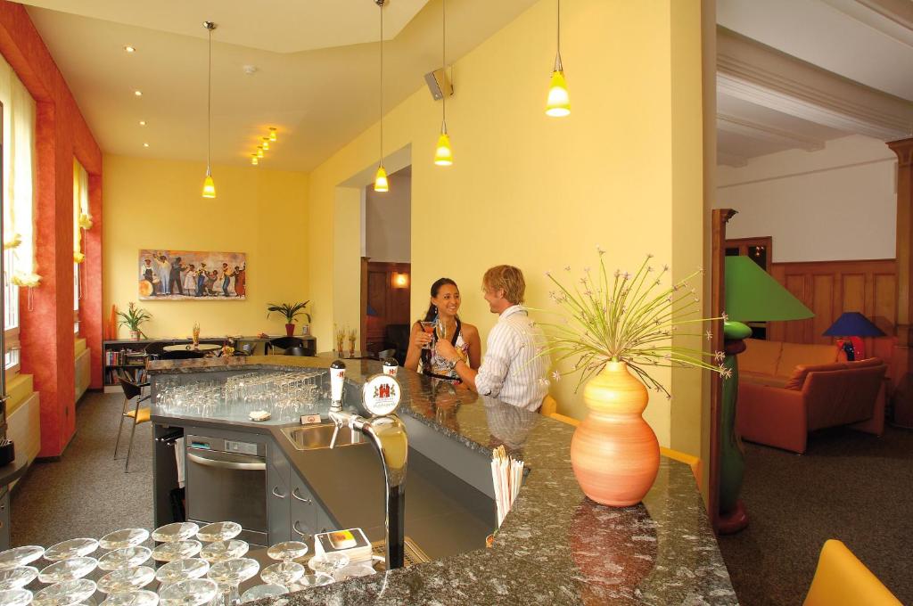 two people standing at a counter in a room at Hotel Schweizerhof in Engelberg