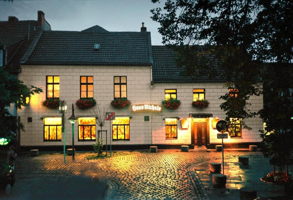 a large white building with lights on at Landhaus Michels garni in Kaarst