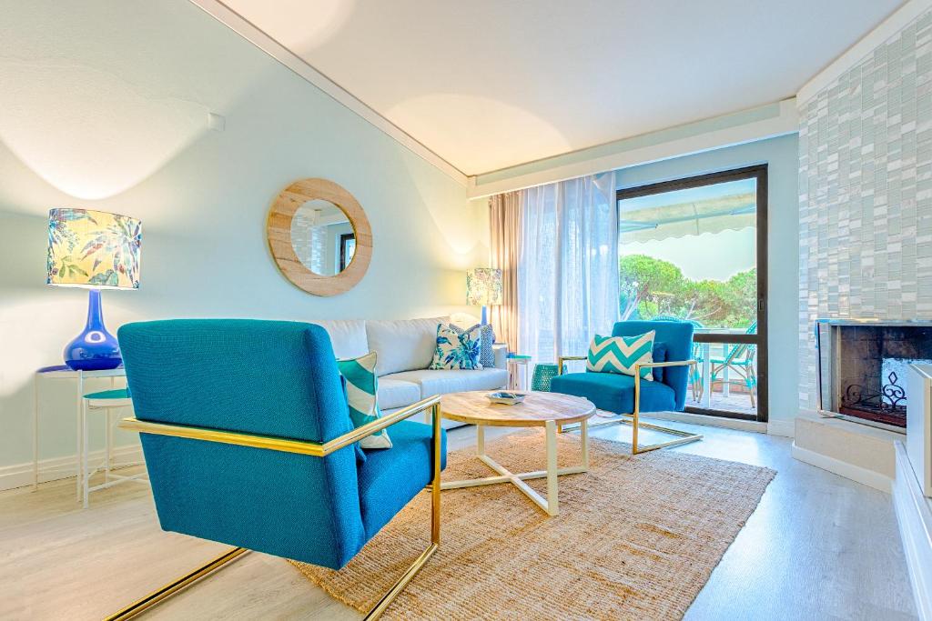 een woonkamer met blauwe stoelen en een open haard bij THE LAKERS Boutique Apartment in Quinta do Lago