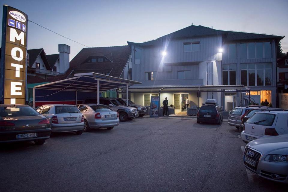 un estacionamiento con autos estacionados frente a un edificio en Motel Magistrala en Doboj