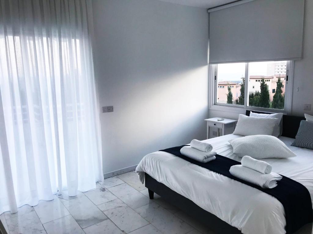 a bedroom with a large bed with towels on it at Olosuites in Limassol