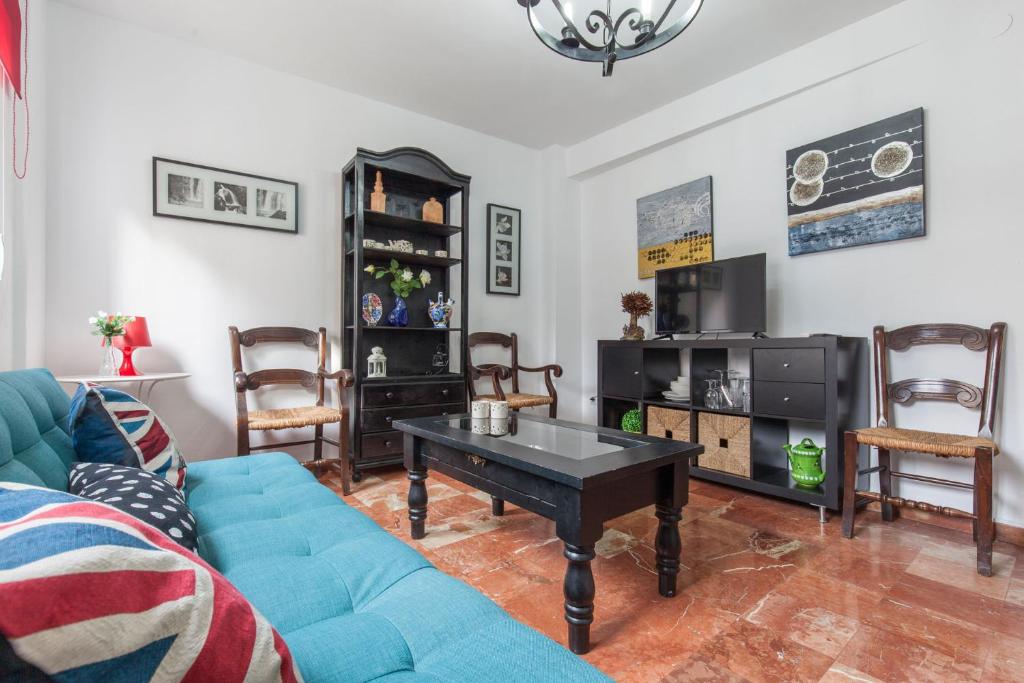 セビリアにあるAcogedor apartamento centro Castellar altoのリビングルーム(青いソファ、テーブル付)